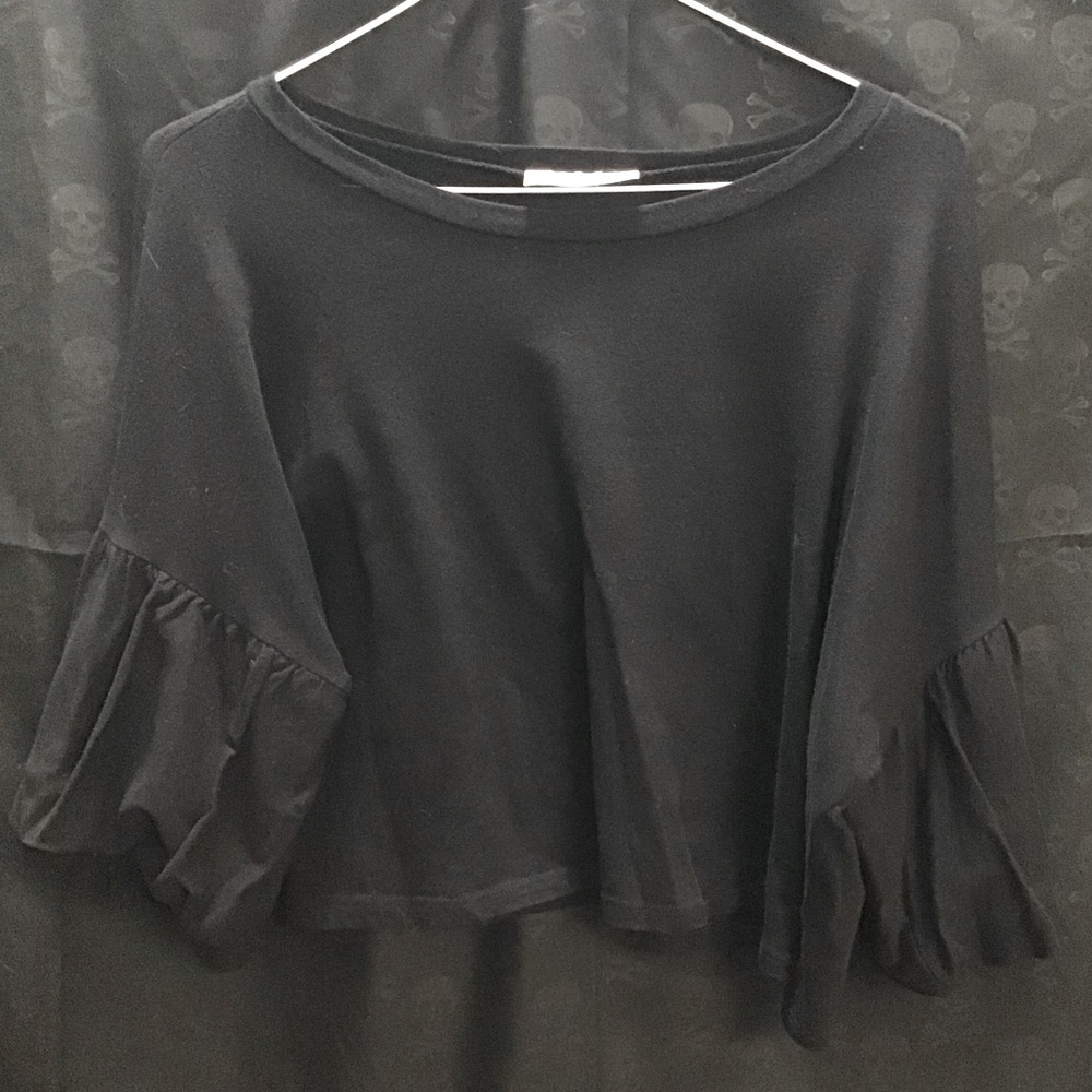 Black 1X crop top with ruffle sleeves.